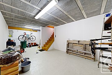 A bicycle is parked in a corner of a room with a sign that says alpine-prop
