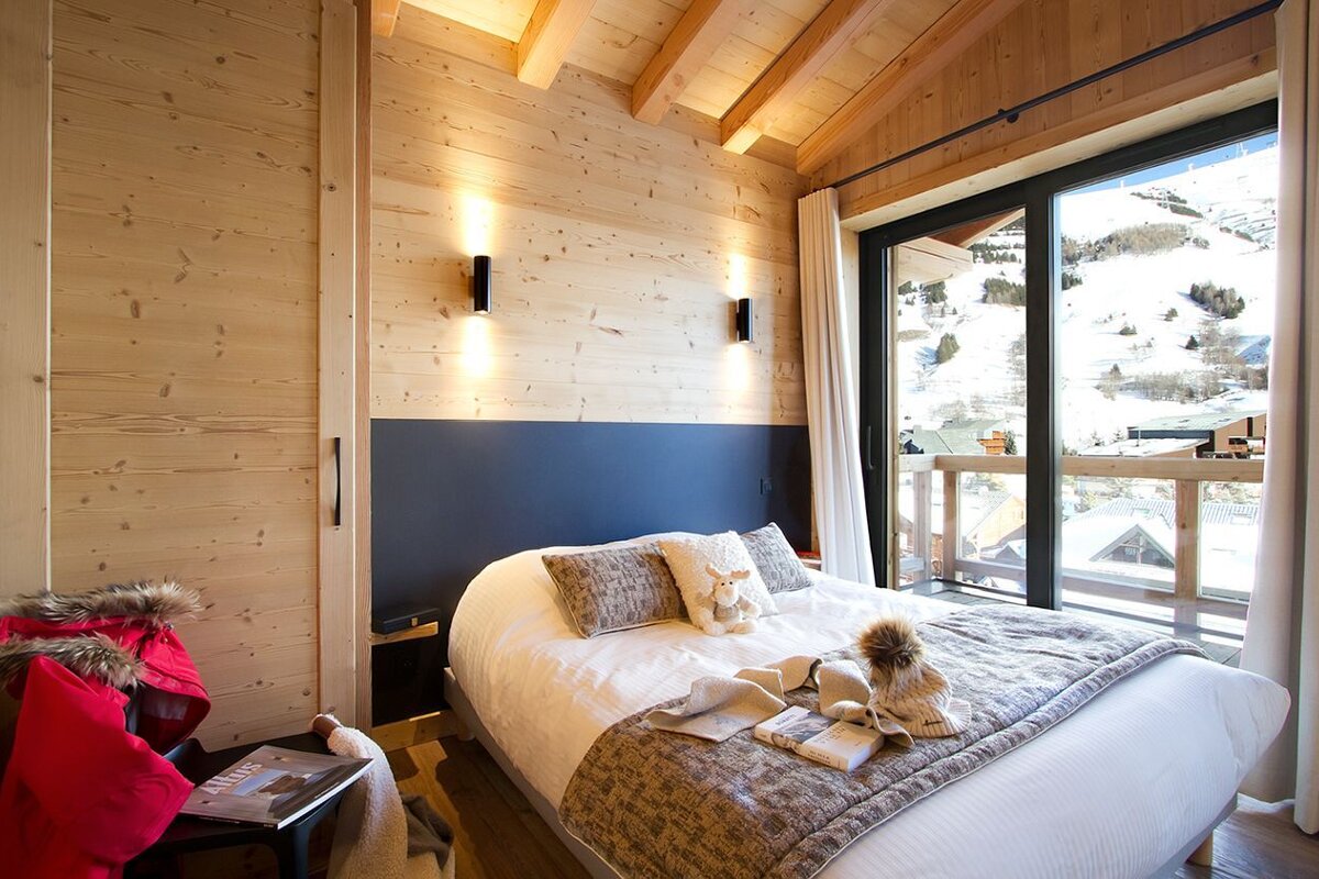 A bedroom with a bed and a large window