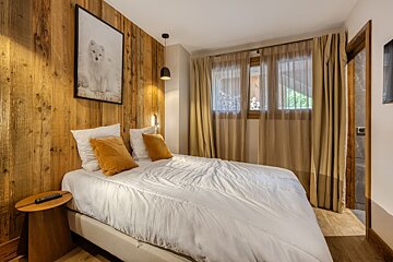 A bedroom with a bed and a picture of a wolf on the wall