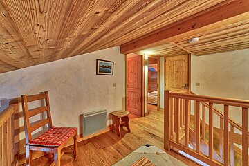 A wooden staircase with a picture on the wall above it