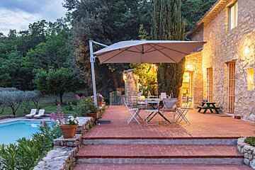A patio with a large umbrella and a table and chairs
