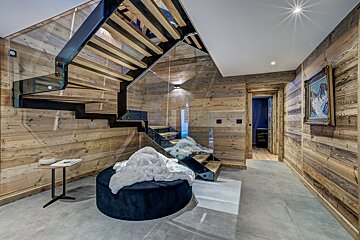 A wooden staircase with a glass railing in a hallway