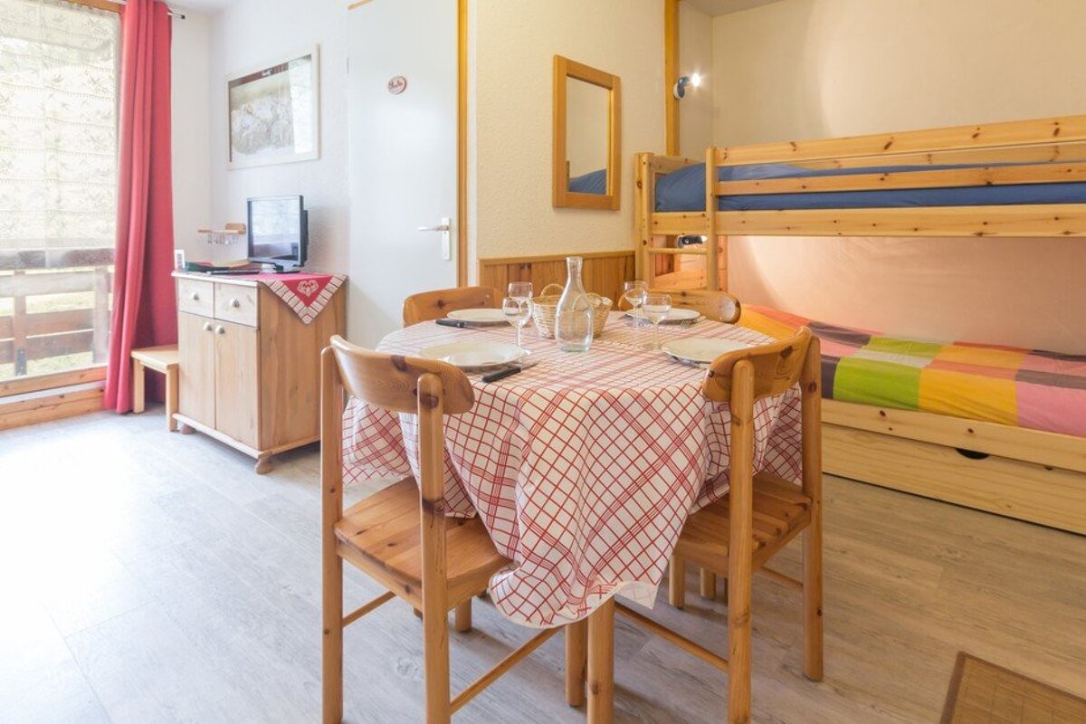A room with a table and chairs and a bunk bed