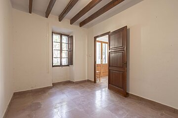An empty room with a wooden door and a window