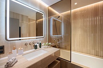 A bathroom with a sink a mirror and a bathtub