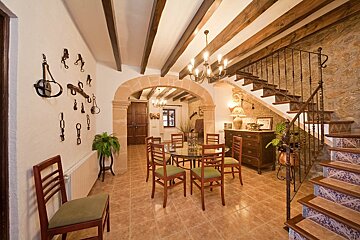 A dining room with a table and chairs and stairs