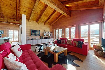 A living room with a red couch and a flat screen tv