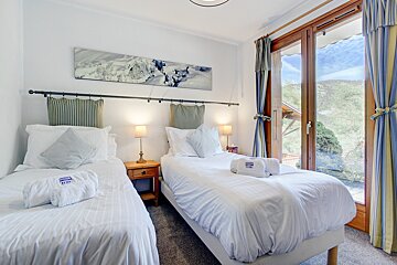 A hotel room with two beds and a painting on the wall