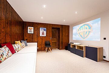A room with a projector screen that says ' warner bros ' on it