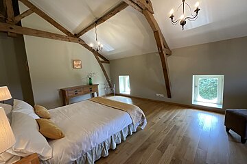 A bedroom with a large bed and a chandelier