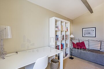 A room with a bookshelf and a couch with a picture on the wall that says ' n ' on it