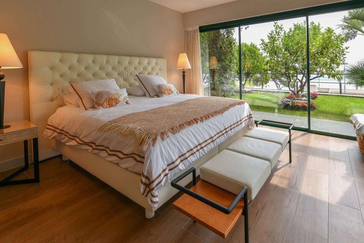 A bedroom with a large bed and a sliding glass door