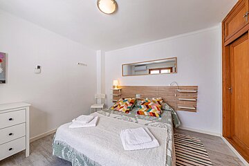 A bedroom with a bed and a mirror on the wall
