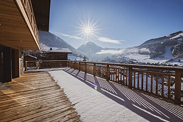 The sun is shining brightly over the snowy mountains