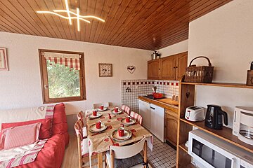 A kitchen with a table and chairs and a toaster