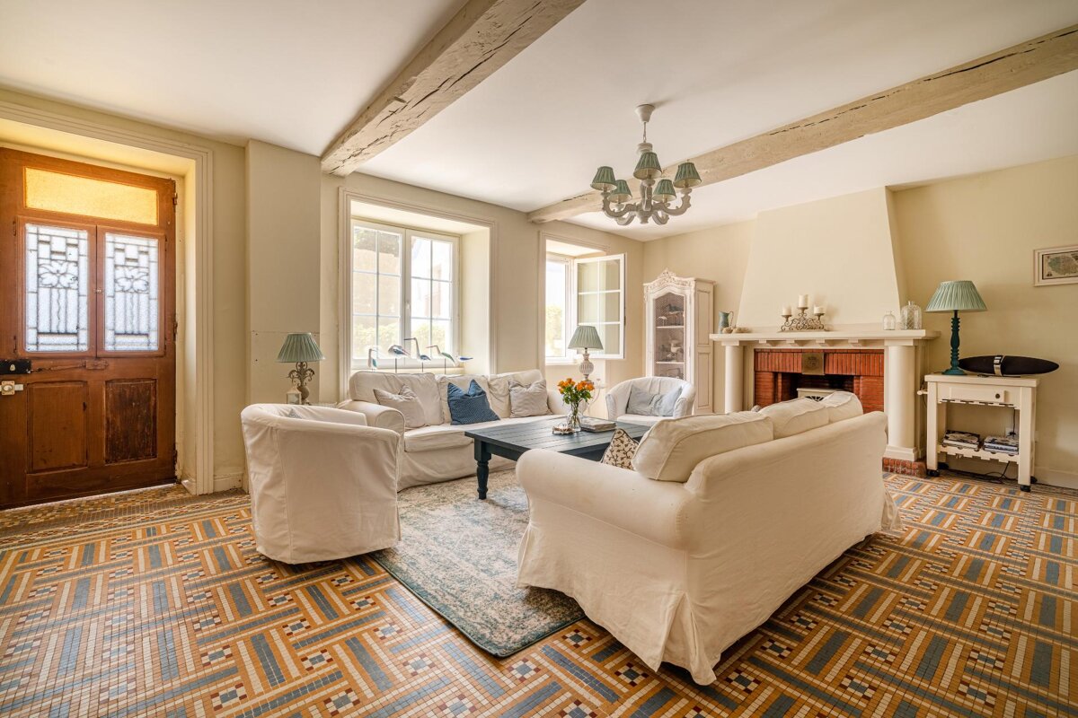 A living room with white furniture and a fireplace