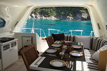 A table with plates and utensils in front of a window overlooking a body of water