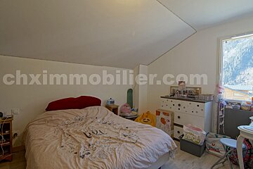 A bedroom with the website chximmobilier.com on the wall