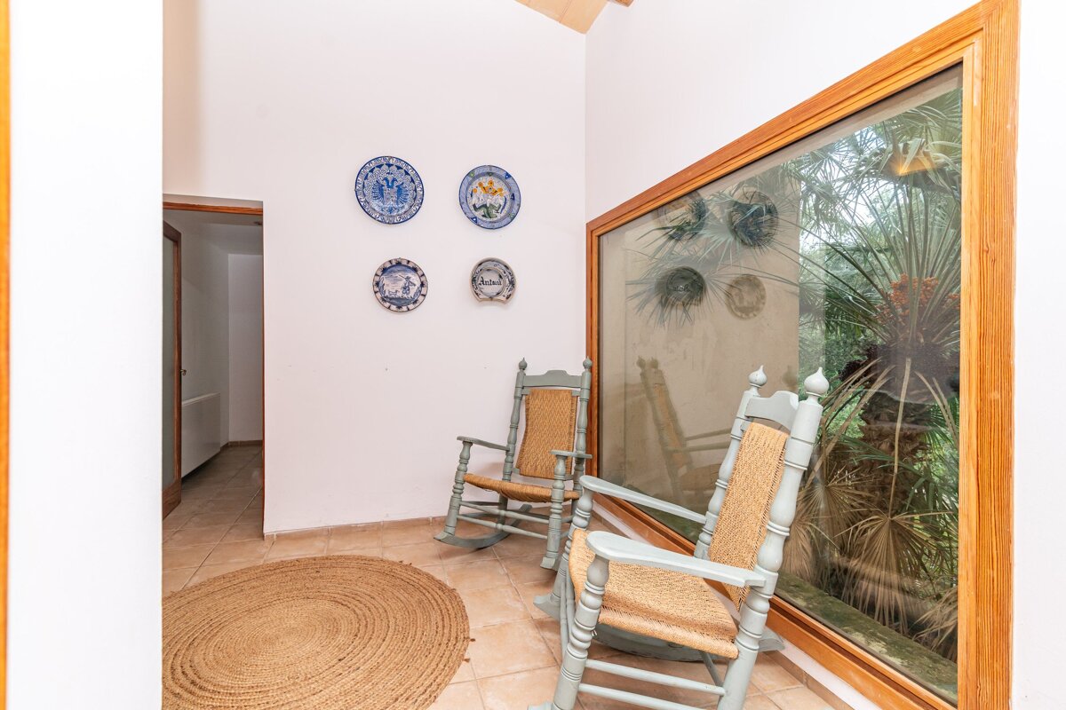 A room with two rocking chairs and plates on the wall