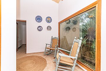 A room with two rocking chairs and plates on the wall