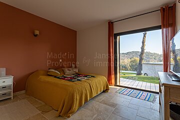 A bedroom with a bed and a sliding glass door that says made in provence by immo