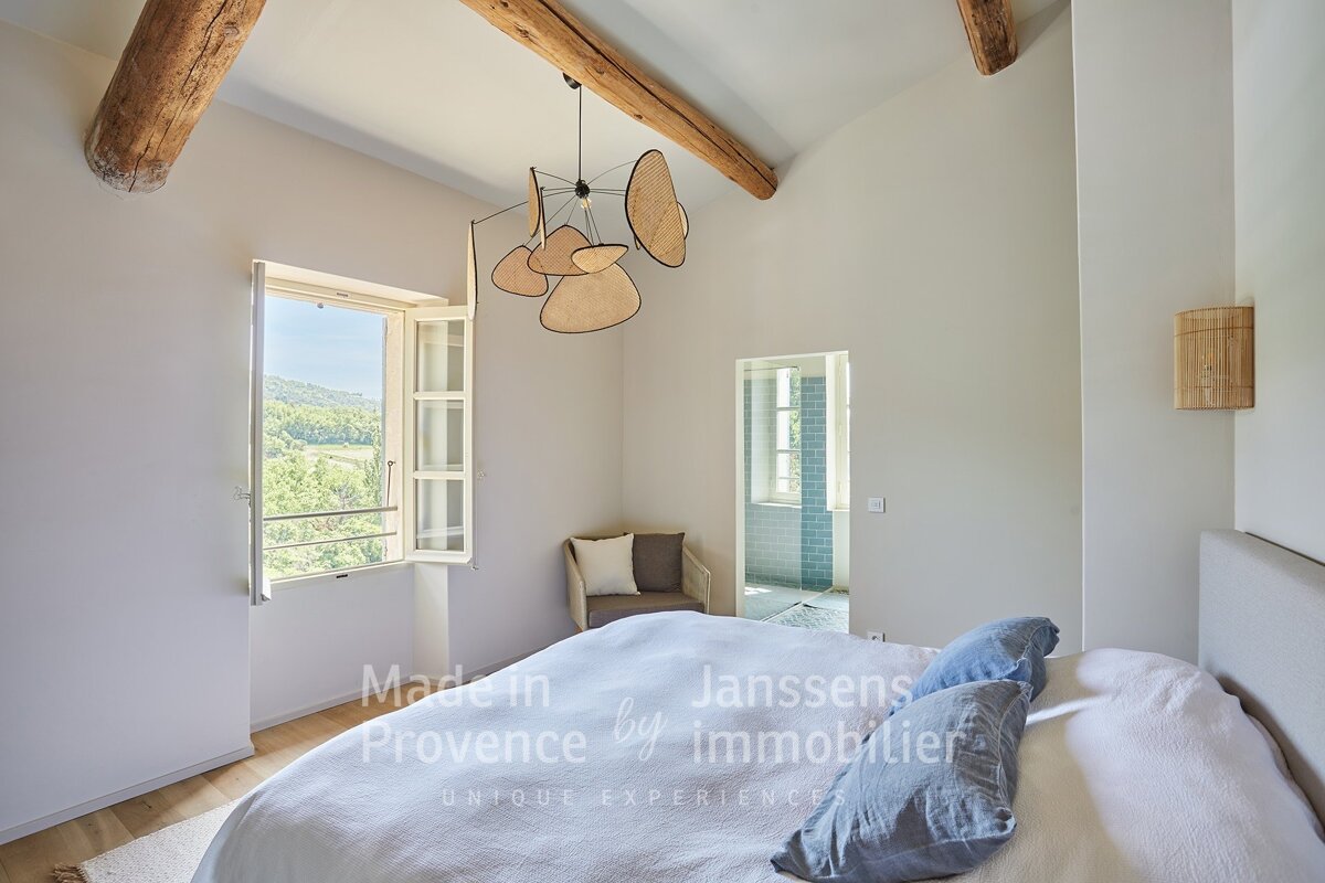 A bedroom with a bed made in provence by immobilier