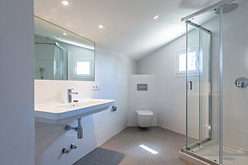 A bathroom with a toilet a sink and a shower