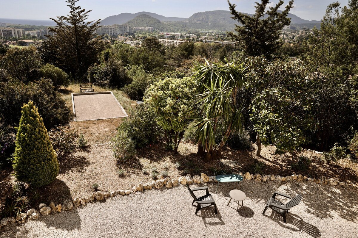Two chairs and a table in a garden with mountains in the background