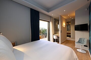 A bedroom with a large bed and a flat screen tv