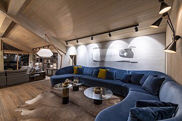 A living room with a blue couch and a painting on the wall