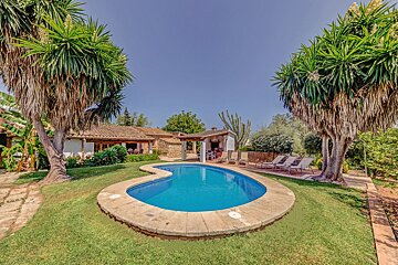 A house with a large swimming pool in front of it