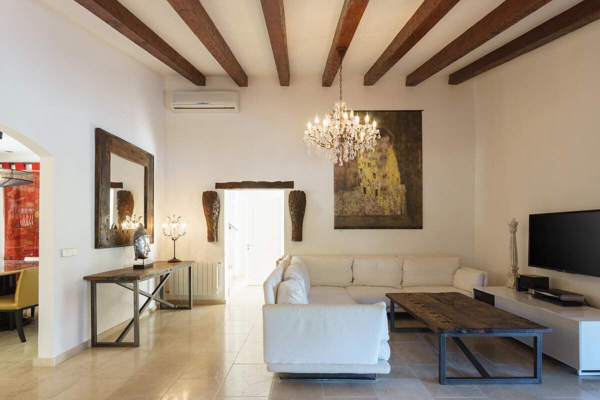 A living room with a chandelier hanging from the ceiling