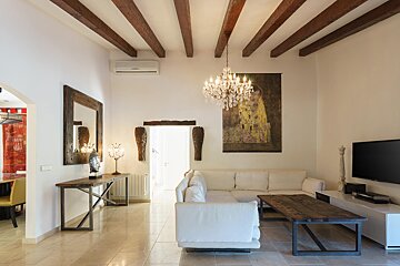 A living room with a chandelier hanging from the ceiling