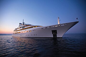 A large white yacht is docked in the ocean