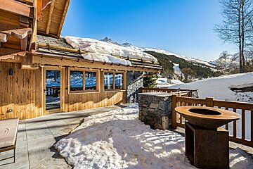A wooden house with snow on the roof