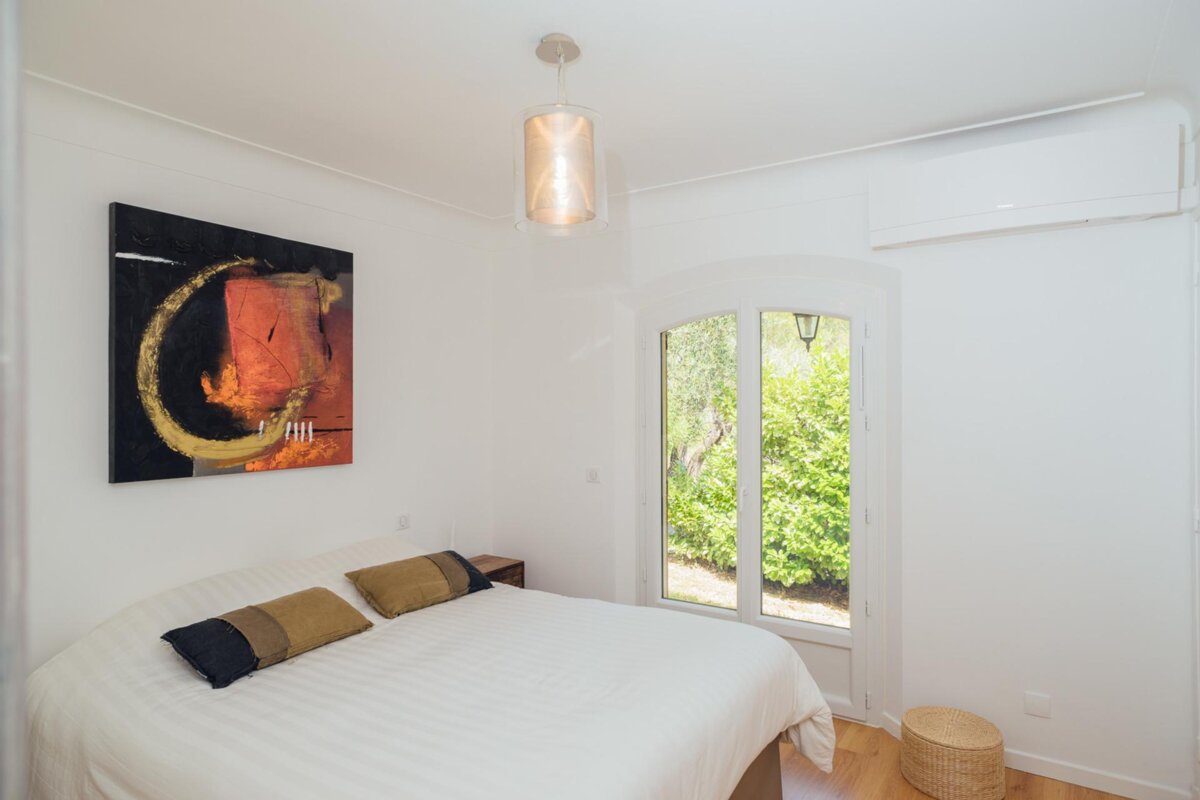 A bedroom with a bed and a painting on the wall