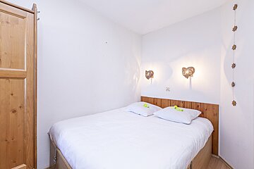 A bedroom with a bed and a wooden headboard