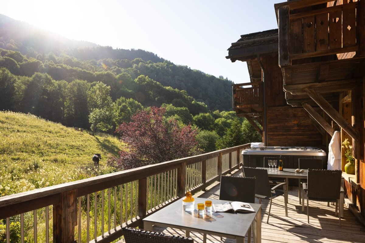 A deck with a table and chairs and a hot tub