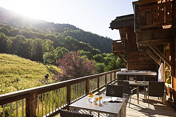 A deck with a table and chairs and a hot tub