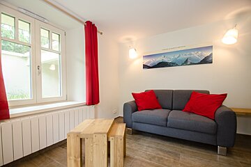 A living room with a couch and a picture of mountains on the wall