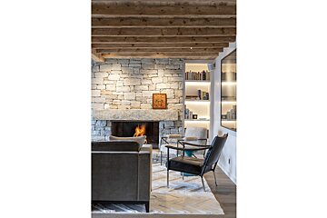 A living room with a stone wall and a fireplace