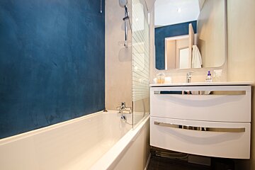 A bathroom with a bathtub a sink and a mirror