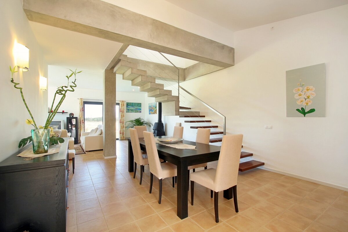 A dining room with a table and chairs and a staircase