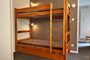 A bunk bed with a drawer underneath it