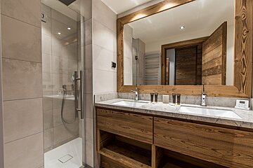 A bathroom with two sinks and a large mirror