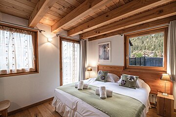 A bedroom with a large bed and a large window