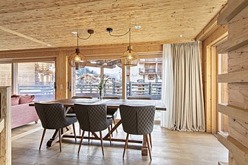 A dining room with a wooden table and chairs