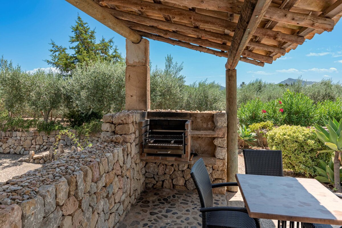 A table and chairs under a wooden roof