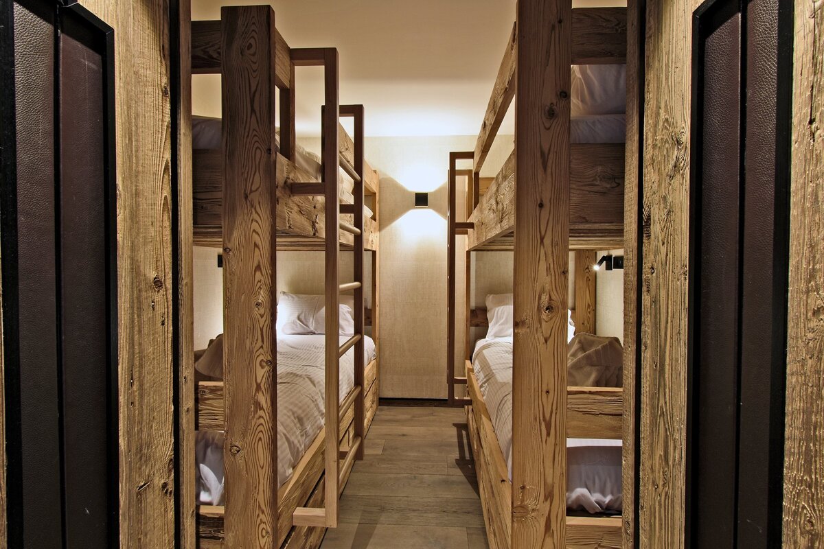 A row of bunk beds are lined up in a hallway