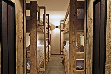 A row of bunk beds are lined up in a hallway